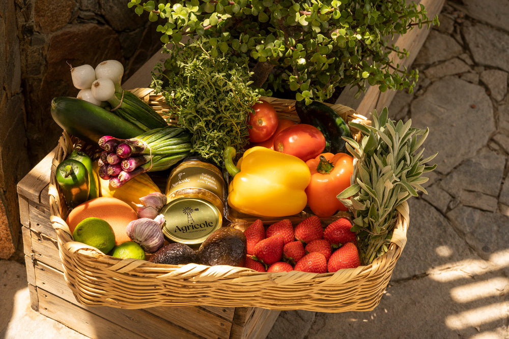 Agricole basket with vegetables, strawberries, herbs and preserves.